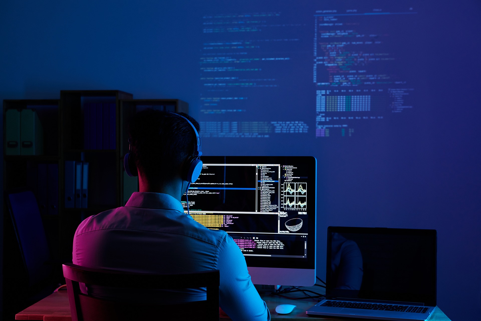 Software Developer working on a computer in a dark room